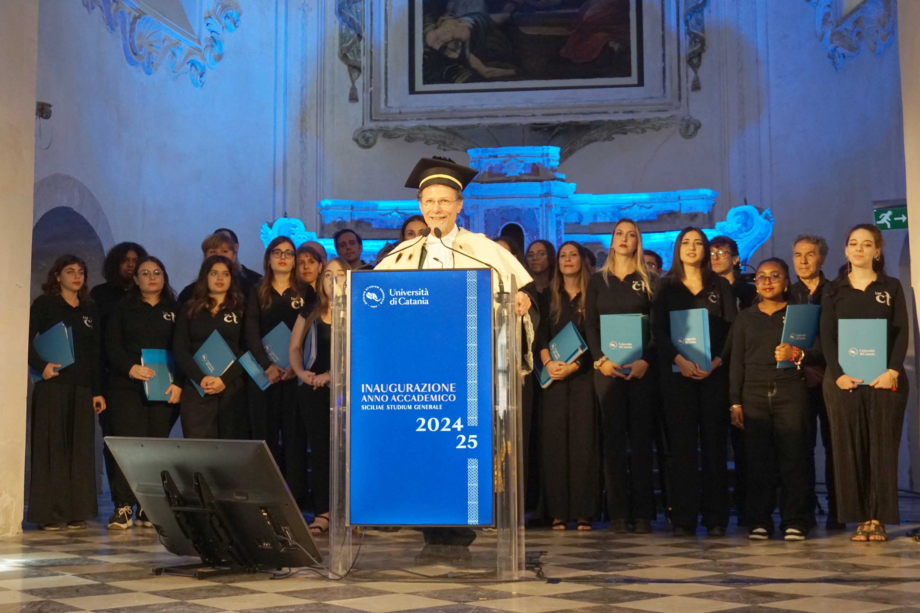 Il rettore Francesco Priolo mentre dichiara aperto l'anno accademico. Alle sue spalle il Coro d'ateneo