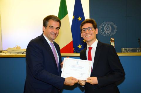 Giulio D'Arrigo mentre riceve il riconoscimento dal ministro Raffaele Fitto